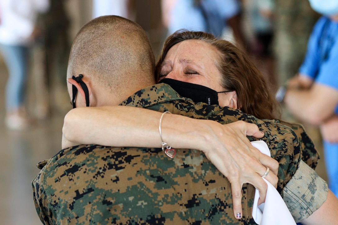 A Marine hugs a loved one.