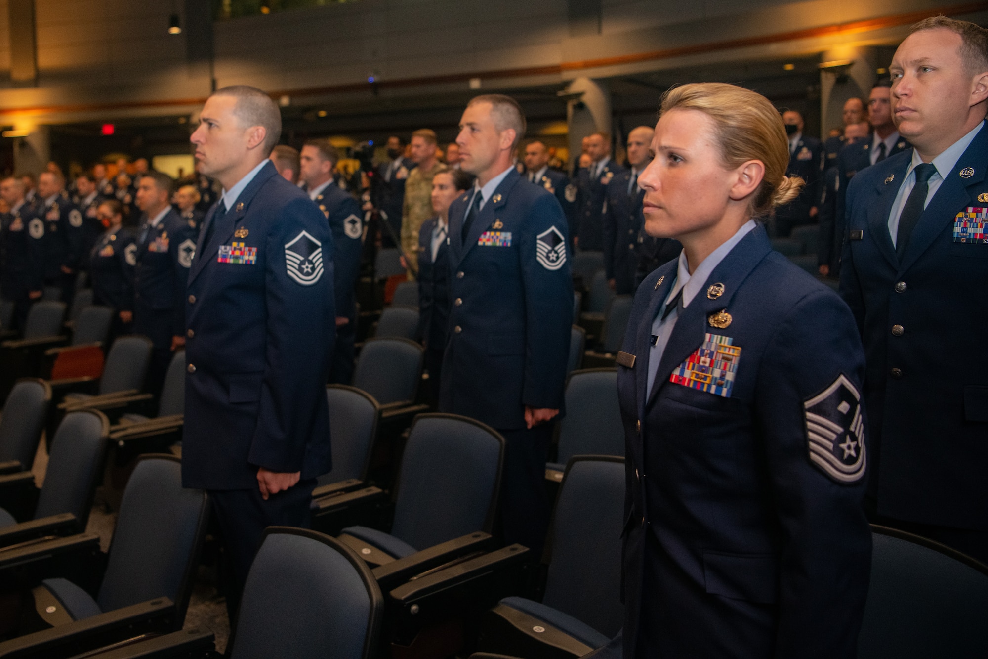 Graduates of Class 21-E stand for the arrival of the official party at a graduation ceremony at the Senior Noncommissioned Officer Academy on Maxwell-Gunter Annex, Alabama, May 26, 2020. The SNCOA held its first in-person graduation ceremony since the World Health Organization declared COVID-19 a pandemic in March 2020.