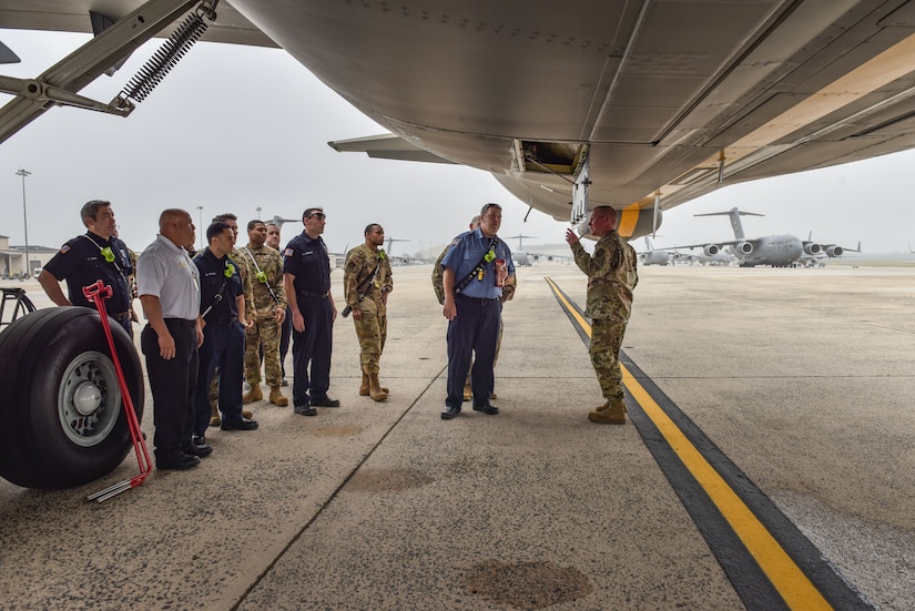 The 87th Civil Engineer Squadron fire department inspect the underside of a KC-46 Pegasus during familiarization training at Joint Base McGuire-Dix-Lakehurst, N.J., May 26, 2021. Familiarization training allows for Airmen to see the aircraft first-hand, thus allowing them to plan for future rescue procedures aboard the airframe. (U.S. Air Force Photo by Senior Airman Shay Stuart)