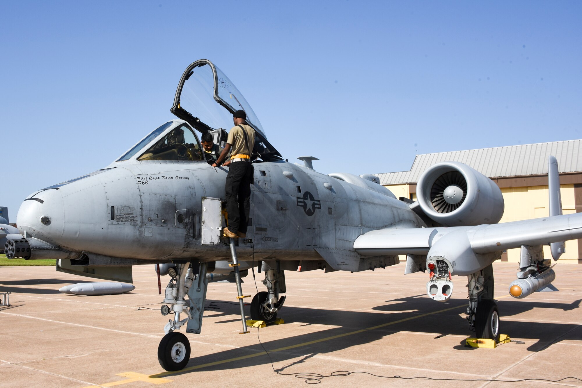 Crew chief helps pilot strap in to an A-10