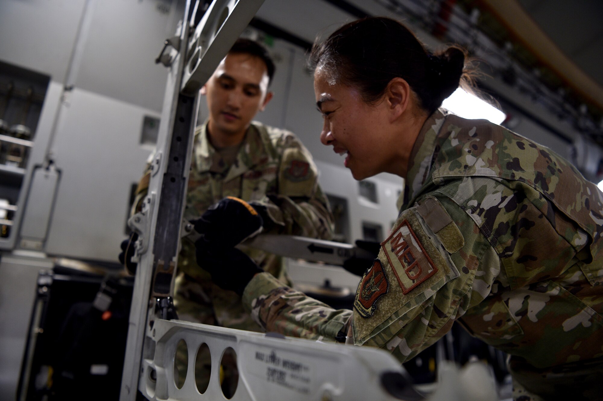 Captain John Penaranda, 624th Civil Engineer Squadron, and Capt. Louise Sarabosing, 624th Aeromedical Staging Squadron, prepare a C-17 for an aeromedical evacuation demonstration at Joint Base Pearl Harbor-Hickam, Hawaii, May 25, 2021. In honor of Asian American Pacific Islander Heritage Month, active duty, Air Force Reserve, and Air National Guard Airmen of Asian American and Pacific Islander descent came together to demonstrate Air Force capabilities for University of Hawaii ROTC cadets. (U.S. Air Force photo by 1st Lt. Amber R. Kelly-Herard)