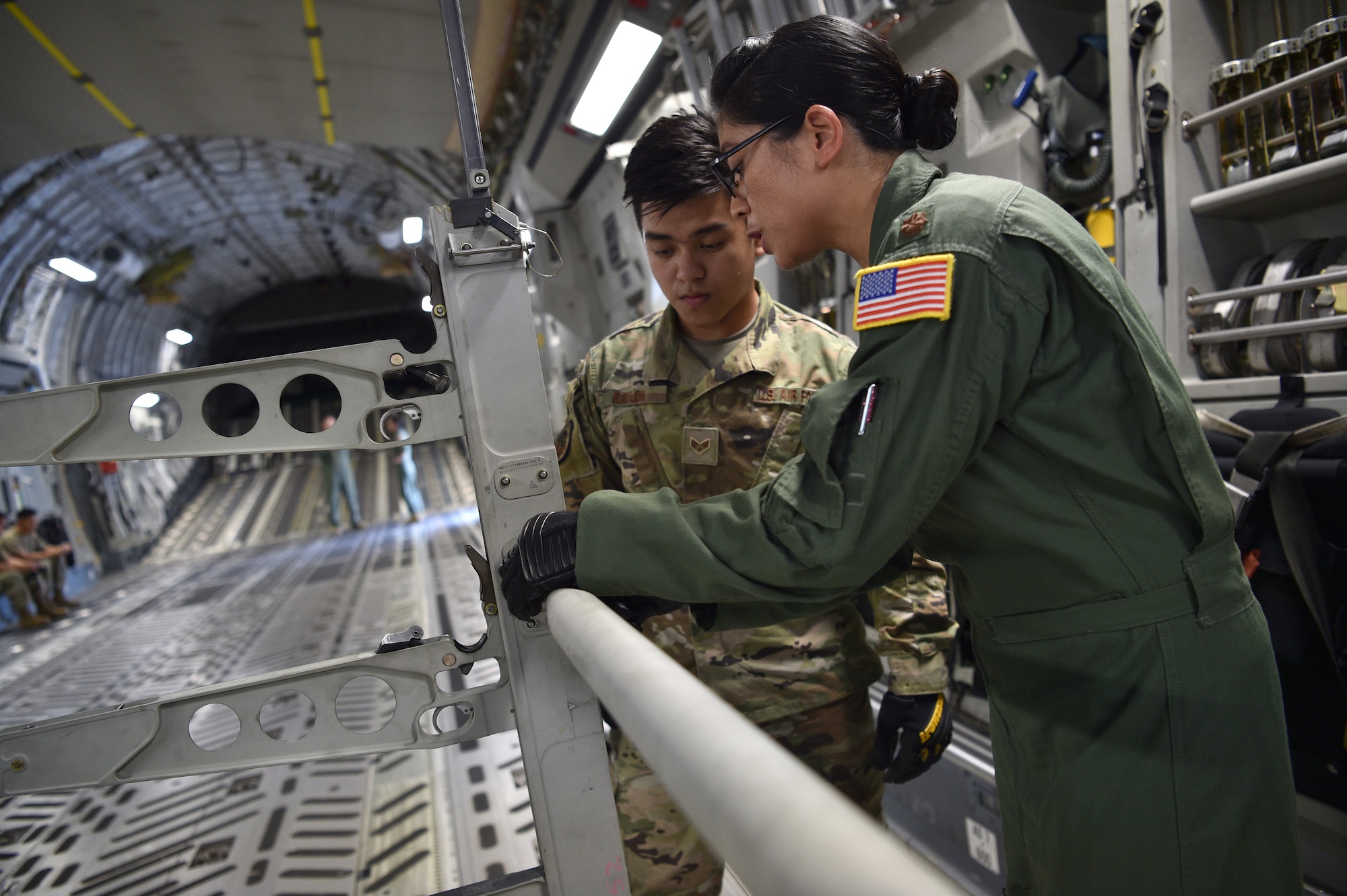 Senior Airman Ramel Baylon, 624th Civil Engineer Squadron, and Maj. Jeanette Williford, 613th Air Operations Center, prepare a C-17 for an aeromedical evacuation demonstration at Joint Base Pearl Harbor-Hickam, Hawaii, May 25, 2021. In honor of Asian American Pacific Islander Heritage Month, active duty, Air Force Reserve, and Air National Guard Airmen of Asian American and Pacific Islander descent came together to demonstrate Air Force capabilities for University of Hawaii ROTC cadets. (U.S. Air Force photo by 1st Lt. Amber R. Kelly-Herard)