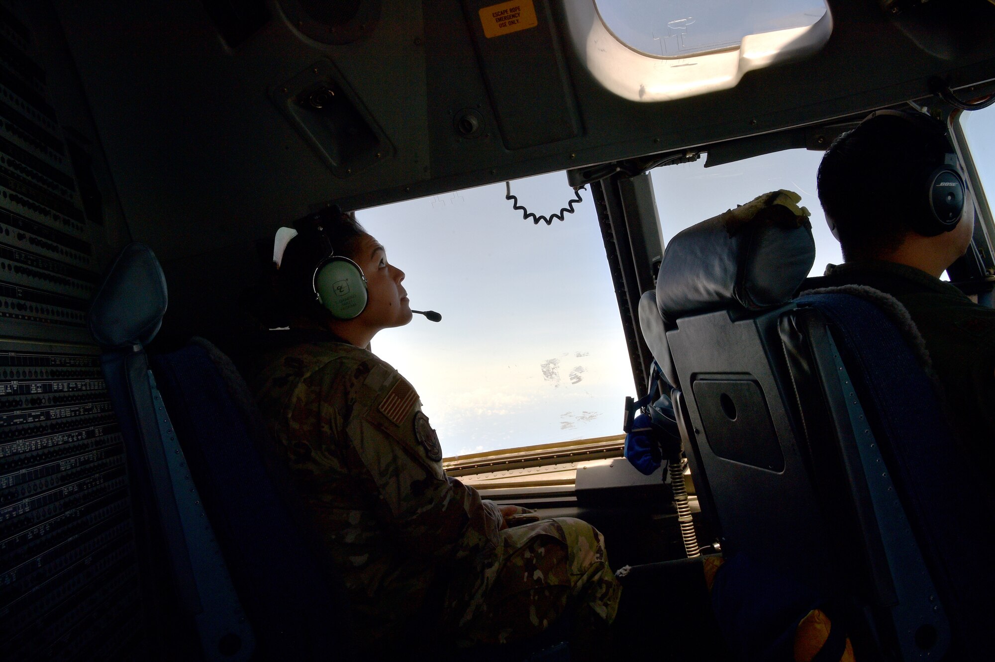 Airman 1st Class Taylor Ganeko, 154th Maintenance Group avionics technician, observes an aerial refueling from the cockpit of a C-17 during her first flight in a military aircraft above the Hawaiian Islands, May 25, 2021. In honor of Asian American Pacific Islander Heritage Month, the 15th Wing and 154th Wing flew a routine training mission composed with aircrew and maintainers who were all of Asian American or Pacific Islander descent and were a mix of active duty and Air National Guard members. (U.S. Air Force photo by 1st Lt. Amber R. Kelly-Herard)