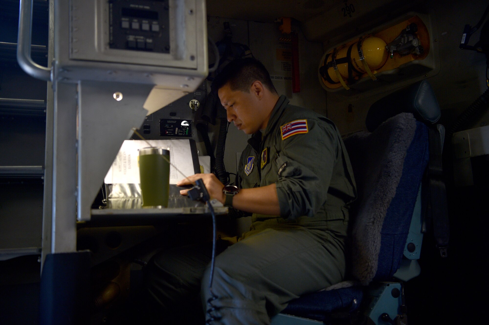 Technical Sgt. Joshua Moracco, 204th Airlift Squadron loadmaster, conducts a pre-flight checklist before taking off at Joint Base Pearl Harbor-Hickam, Hawaii, May 25, 2021. In honor of Asian American Pacific Islander Heritage Month, the 15th Wing and 154th Wing flew a routine training mission composed with aircrew and maintainers who were all of Asian American or Pacific Islander descent and were a mix of active duty and Air National Guard members. (U.S. Air Force photo by 1st Lt. Amber R. Kelly-Herard)