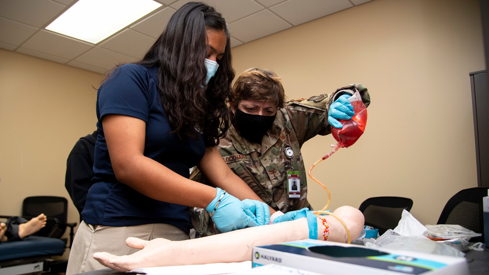 U.S. Air Force Col. Cheryl Lockhart, the 6th Medical Group (MDG) chief nurse, and a Cristo Rey Tampa Salesian High School student, administer a practice IV at MacDill Air Force Base, Florida, May 26, 2021.