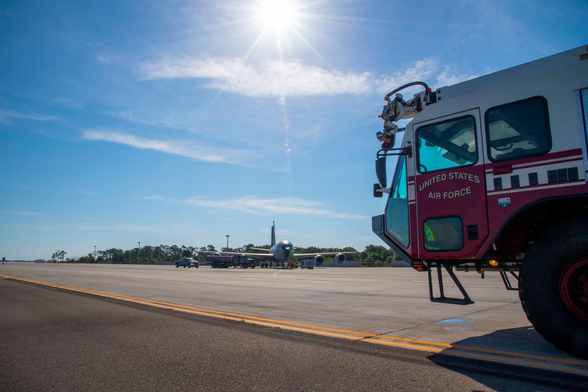 A firetruck assigned to the 6th Civil Engineer Squadron (CES) stands by as KC-135 Stratotanker aircraft hot pit refueling is conducted at MacDill Air Force Base, Florida, May 25, 2021. The 6th CES Airmen supported the operation in the event an emergency occurred during the hot pit refueling. (U.S. Air Force photo by Airman 1st Class Hiram Martinez)