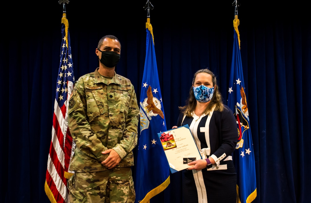 Ms. Tricia Sulham, lead key spouses in Production Corps, receives the Volunteer Excellence Award presented by Lt Col John Francis, 61st Air Base Group IMA to the Deputy Commander, during the Los Angeles Air Force Base Volunteer Appreciation ceremony in the Gordon Conference Center, LAAFB, El Segundo, Calif., April 15, 2021. (U.S. Space Force photo by Van Ha)