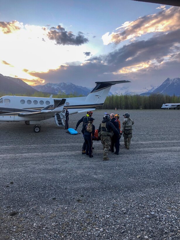 Pararescue personnel with the Alaska Air National Guard’s 212th Rescue Squadron transload an injured hiker from a 210th Rescue Squadron HH-60 Pave Hawk to a Guardian Flight, AirMedCare air ambulance after conducting a multi-agency rescue from an avalanche near Donoho Peak in Wrangle-Saint Elias National Park and Preserve May 26, 2021. (Courtesy photo by Stephens Harper)