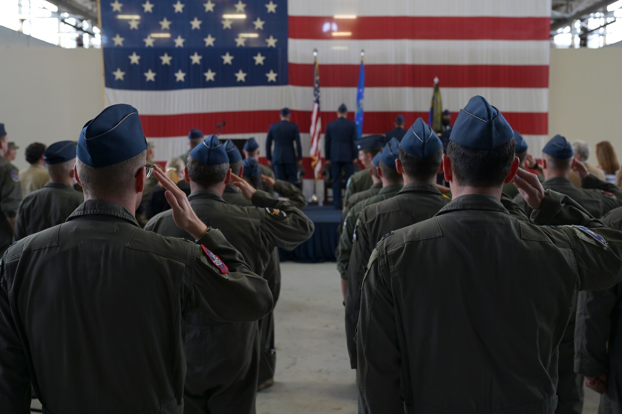 Airmen from the 37th Flying Training Squadron and audience members salute during the playing of the national anthem at the 37th FTS change of command ceremony May 27, 2021, on Columbus Air Force Base, Miss. The 37th FTS conducts primary flight training in the T-6A Texan II where students learn basic aircraft characteristics and control, takeoff and landing techniques, aerobatics, and night, instrument and formation flying. (U.S. Air Force photo by Senior Airman Jake Jacobsen)