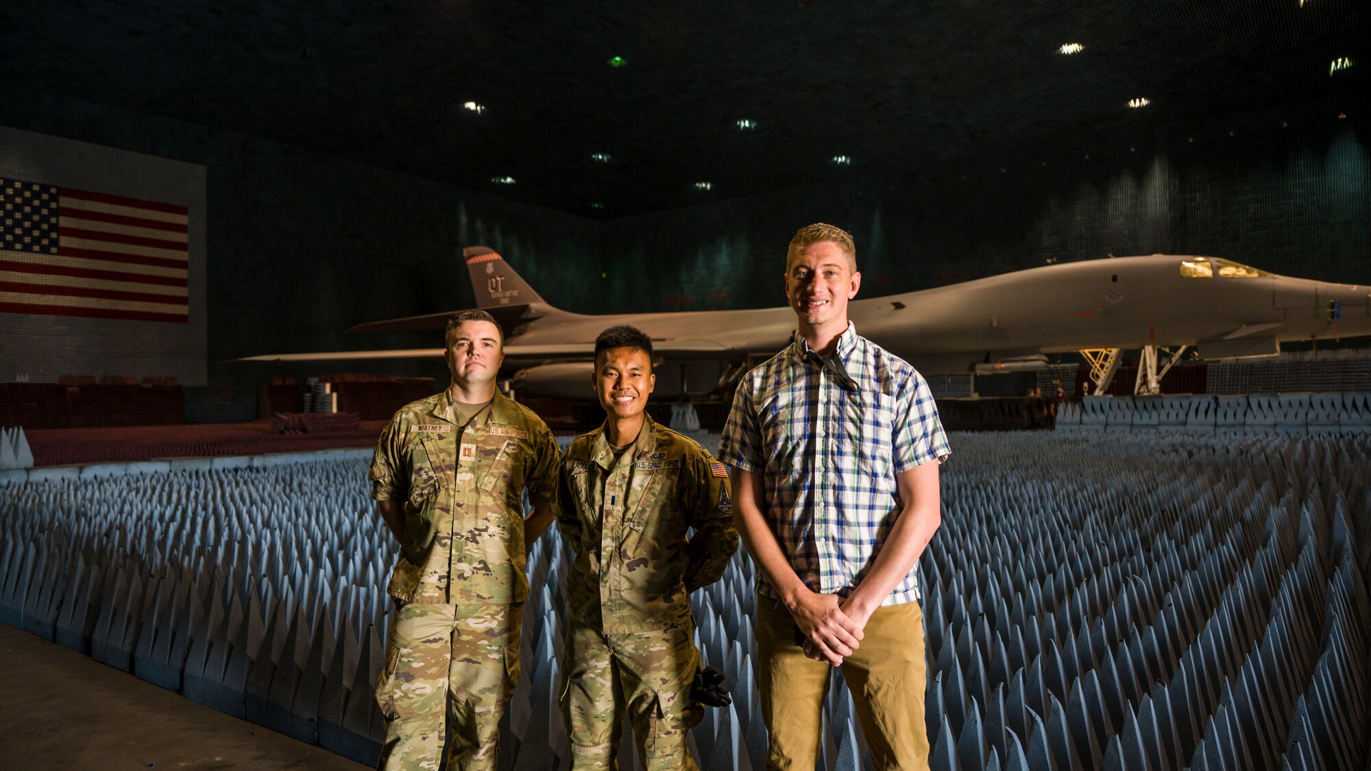 PFS 6.42 project test lead engineer, Capt. Shawn Whitney, BAF project engineer, 1st Lt. Kevin Lasquete, and BAF Project Manager, Justin Duhart, pose for a photo in front of a B-1B Lancer inside the Benefield Anechoic Facility at Edwards Air Force Base, California, May 20. The Lancer, from the 337th Test and Evaluation Squadron, 53rd Wing, out of Dyess Air Force Base, Texas, will be used to conduct testing of PFS 6.42. (Air Force photo by Giancarlo Casem)