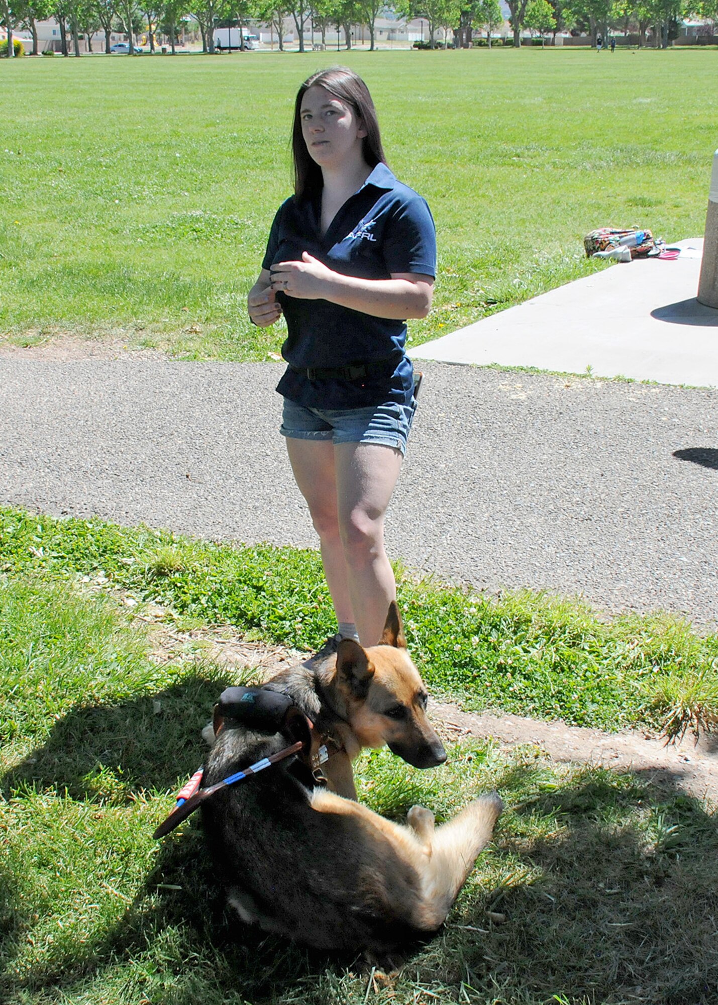 A woman and her service dog give a presentation outside.