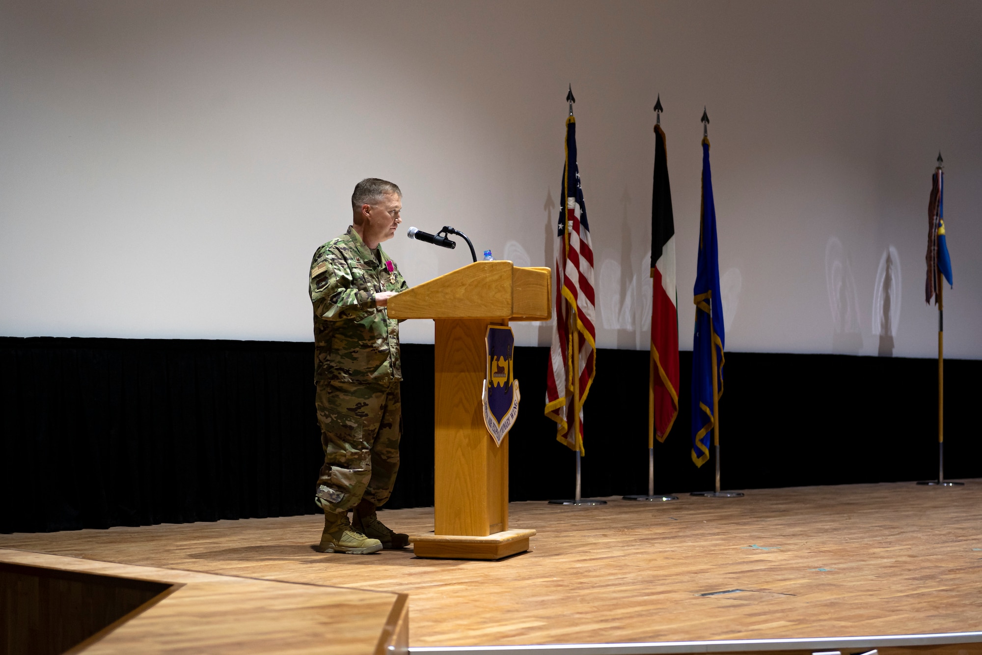 A photo of an Airman speaking at a ceremony