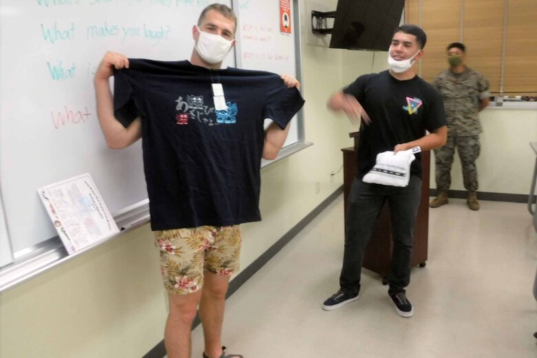 基地内で開催されている地域住民のための社会人英語講座で、受講者たちから贈られた沖縄のTシャツを広げるブライアン・ゴフ中尉、２０２１年５月２６日、米海兵隊基地キャンプ・シュワブ教育センター