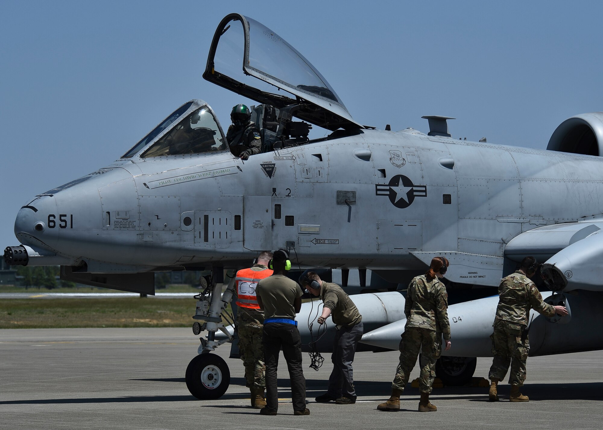 Service members work around a parked aircraft.