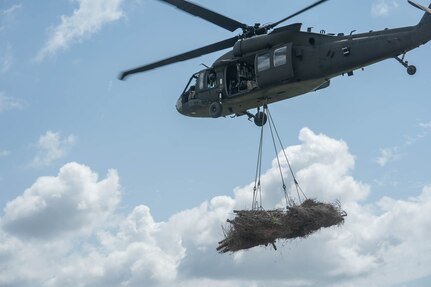 The Louisiana National Guard’s 1st Battalion, 244th Aviation Regiment, in support of the U.S. Fish and Wildlife Service, loads and transports bundles of recycled Christmas trees provided by Orleans Parish residents to rebuild marshland in Bayou Sauvage in New Orleans East May 26, 2021. The trees create new marsh habitats.