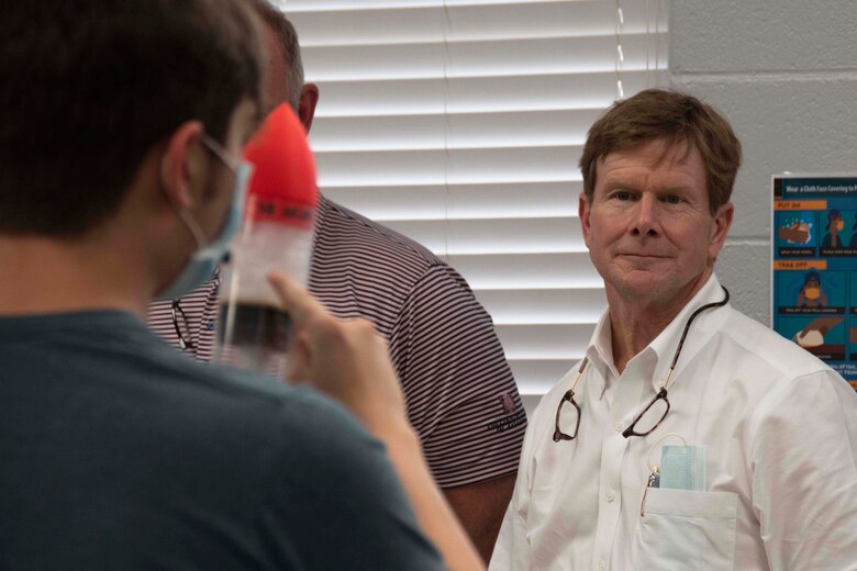 Photo of civilian watching rocket building demonstration.