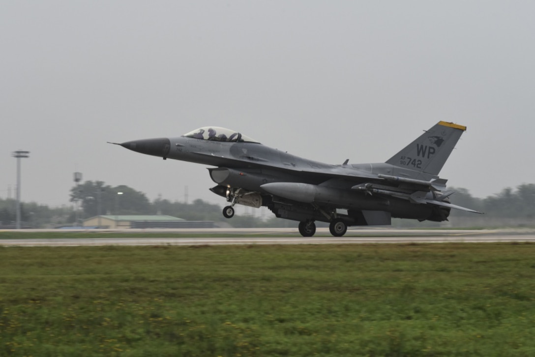 A military plane lands on a runway.