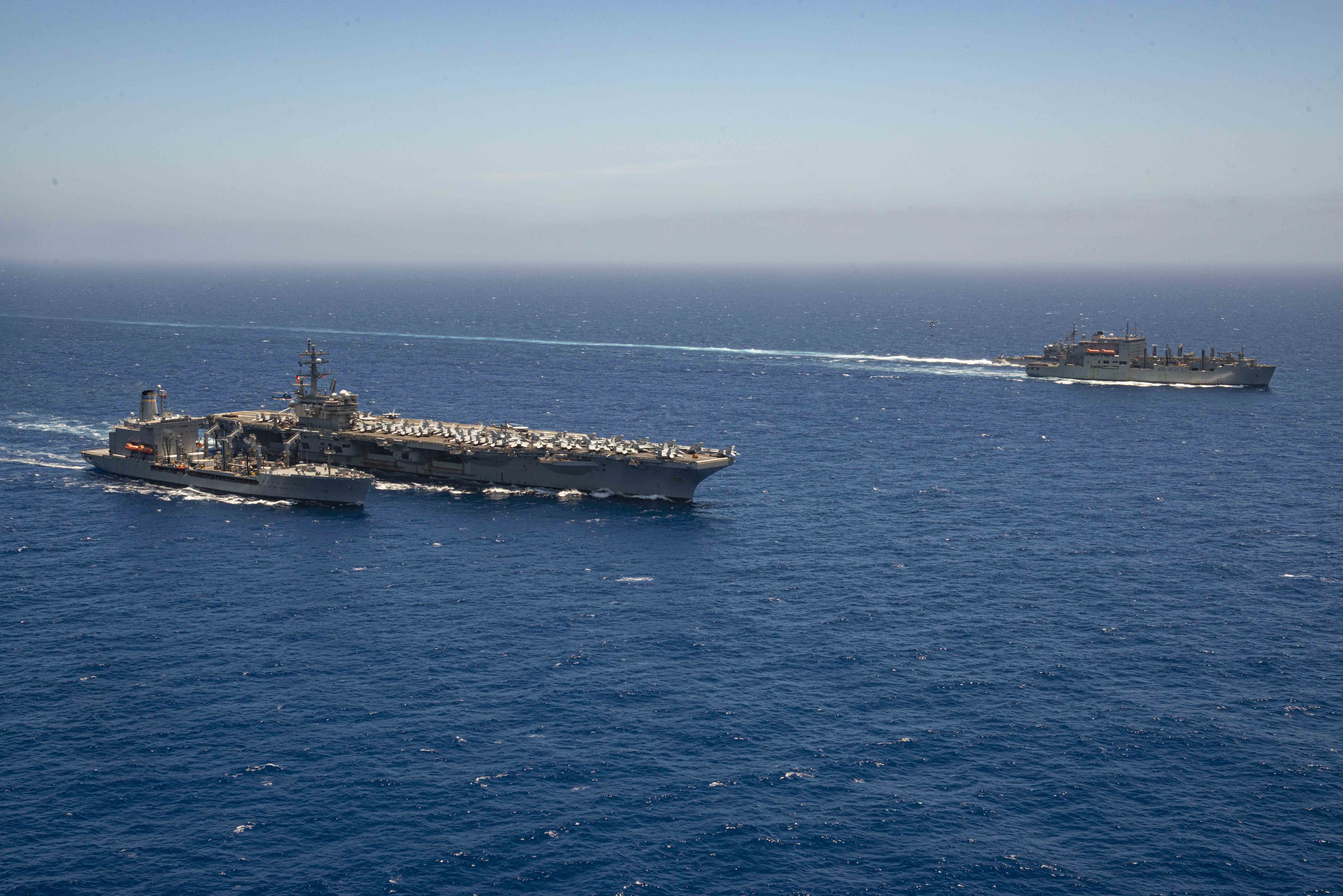 USS Ronald Reagan (CVN 76), conducts a fueling-at-sea with the fleet replenishment oiler USNS Pecos (T-AO 195), while USS Shiloh (CG 67) prepares to conduct a replenishment-at-sea with USNS Charles Drew (T-AKE 10).