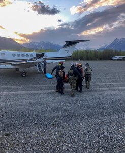 Pararescue personnel with the Alaska Air National Guard’s 212th Rescue Squadron transfer an injured hiker from a 210th Rescue Squadron HH-60 Pave Hawk to a Guardian Flight, AirMedCare air ambulance after a multiagency rescue from an avalanche near Donoho Peak in Wrangle-Saint Elias National Park and Preserve May 26, 2021.