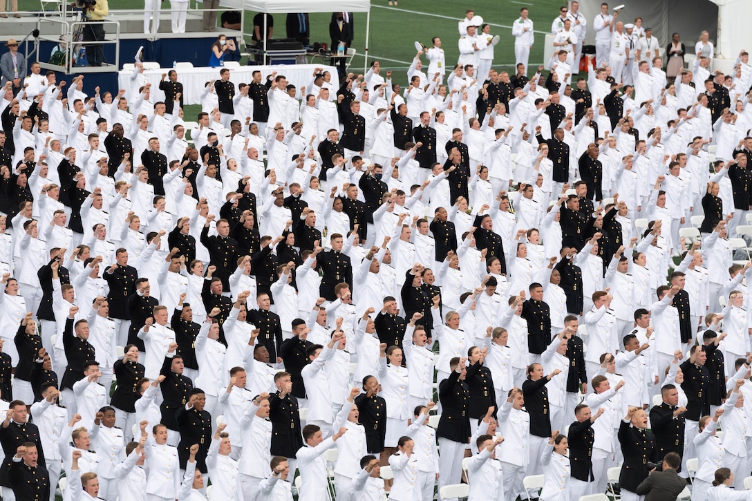 A large group of graduating sailors participate in a ceremony.