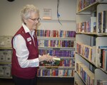 Joy Moore, volunteer, sorts books in the Patient Library at Brooke Army Medical Center.