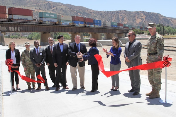 Representatives of local, county, state and federal agencies gather near the Santa Ana River in Corona, California, May 27, 2021, to mark the official completion of the BSNF Railroad Bridge Pier Protection Project in Corona, California. The purpose of the project is to minimize risk to the bridge in flood conditions and during increased water releases from Prado Dam resulting from periods of heavy rainfall.