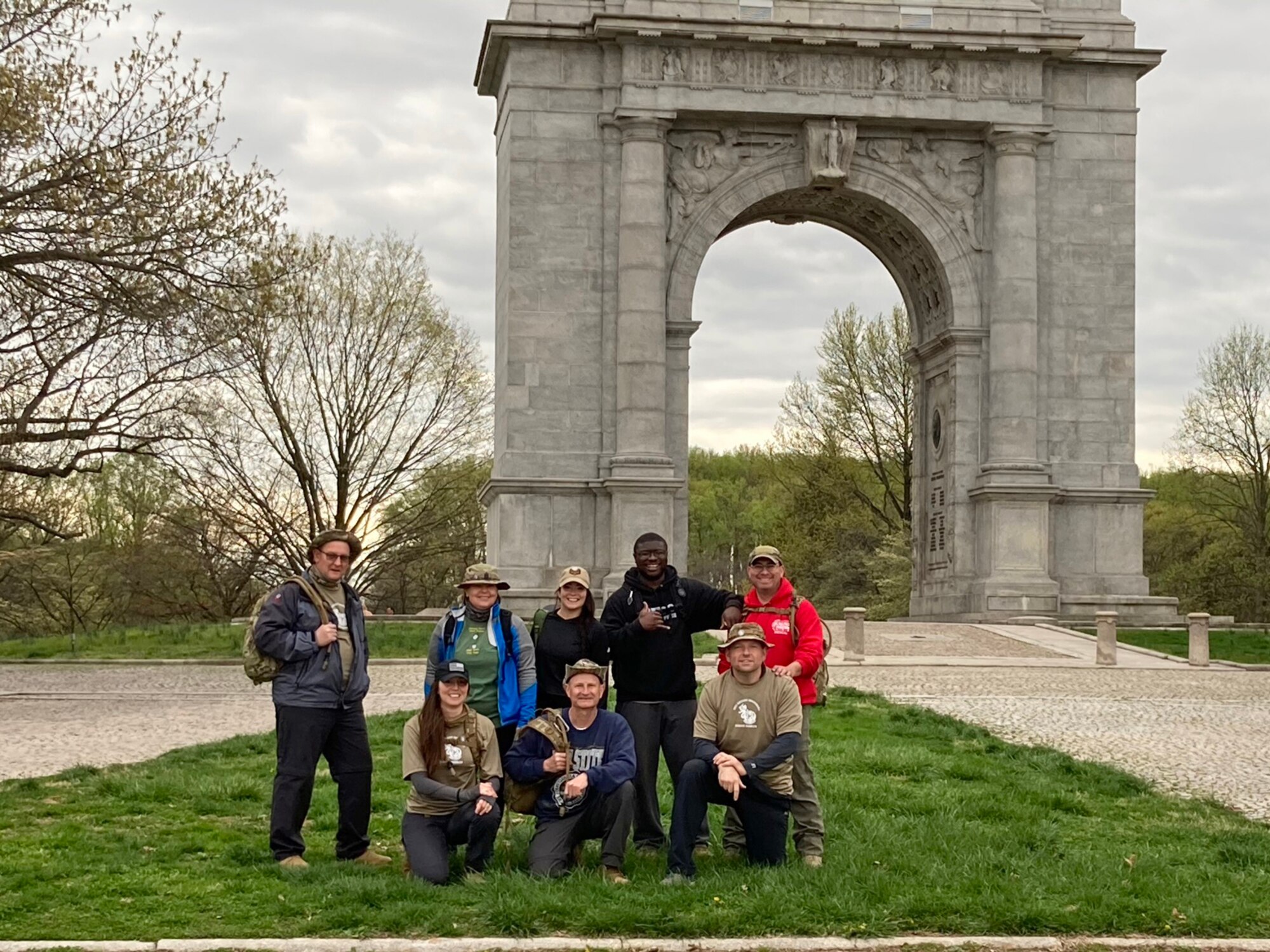 A group of people pose for a photo outside during a hike.