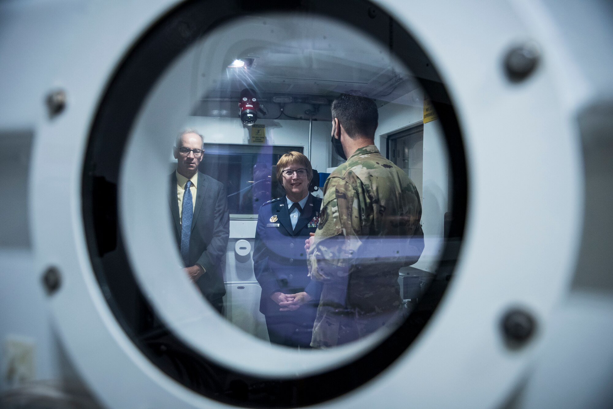 Lt. Col. Nathan Maertens, aerospace physiology division chief in the 711th Human Performance Wing, speaks with Lt. Gen. Dorothy Hogg, Air Force Surgeon General, and Lt. Gen. Mark Ediger (ret.), inside research altitude chamber three following a ribbon-cutting ceremony May 27 hosted by the Air Force Research Laboratory’s 711 HPW. (U.S. Air Force photo by Richard Eldridge)