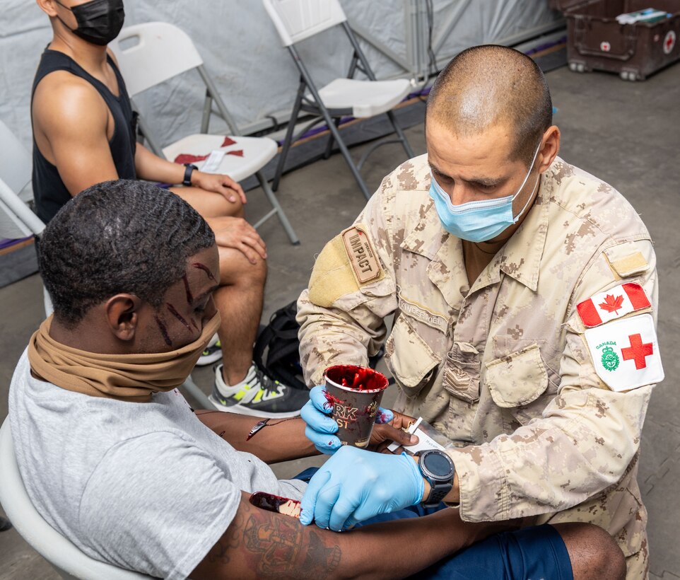 Person puts on moulage on a simulated casualty.