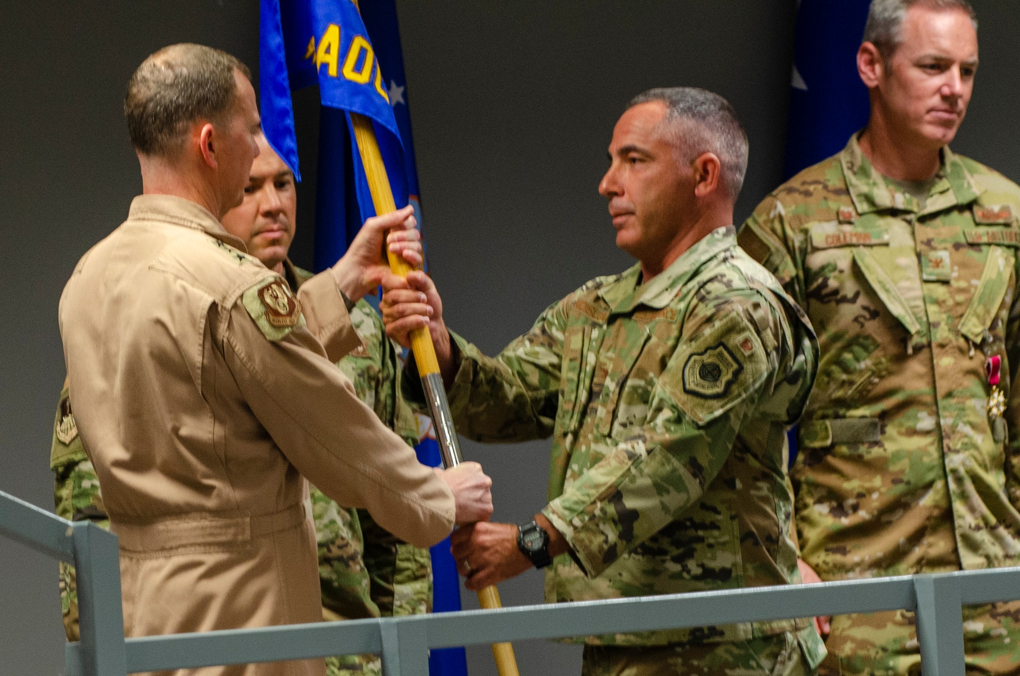 U.S. Air Force Lt. Gen. Greg Guillot, 9th Air Force (Air Forces Central) commander, left, passes the unit guidon to Col. Joshua Koslov, 609th Air Operations Center commander, during the 609th AOC change of command ceremony Al Udeid Air Base, Qatar, May 27, 2021. The Airmen of the 609th AOC work alongside joint and international partners from 18 nations to plan, produce, and execute the daily Air Tasking Order on behalf of Guillot, who also serves as the Combined Forces Air Component Commander. (U.S. Air Force photo by Tech. Sgt. Dylan Nuckolls)