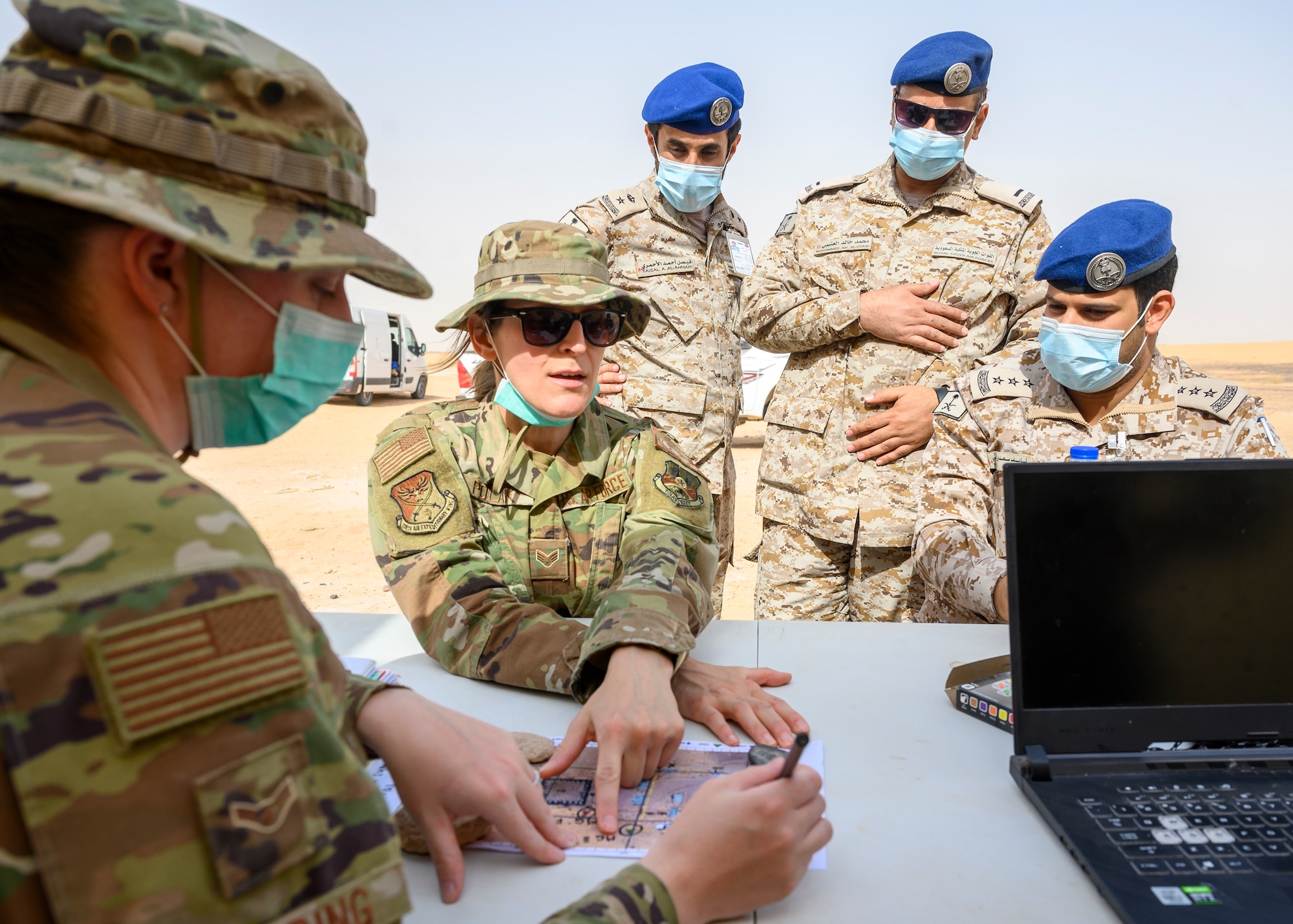Senior Airman Magdalena Polak, 378th Air Expeditionary Wing Host Nation Coordination Cell translator, relays the planned actions for a chemical, biological, radiological and nuclear response exercise to members of the Royal Saudi Air Force, Prince Sultan Air Base, Kingdom of Saudi Arabia, May 26, 2021. The combined exercise demonstrates the emergency management integration between USAF and RSAF CBRN response units while also familiarizing each unit with the other’s techniques and procedures. (U.S. Air Force photo by Senior Airman Samuel Earick)