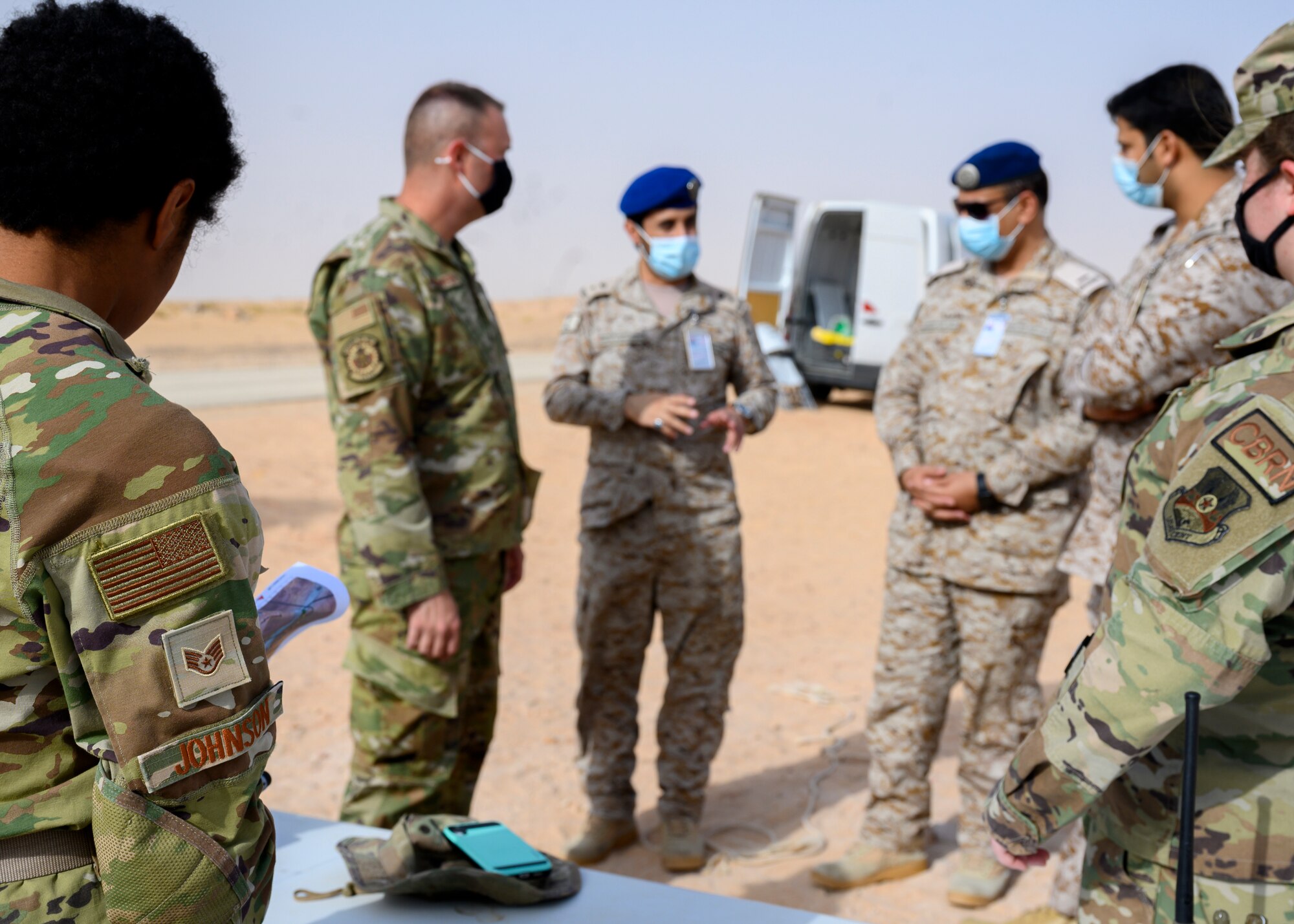 Royal Saudi Air Force personnel discuss the steps of a chemical, biological, radiological and nuclear response exercise with members of the 378th Civil Engineer Squadron emergency management flight, Prince Sultan Air Base, Kingdom of Saudi Arabia, May 26, 2021. The combined exercise demonstrates the emergency management integration between USAF and RSAF CBRN response units while also familiarizing each unit with the other’s techniques and procedures. (U.S. Air Force photo by Senior Airman Samuel Earick)