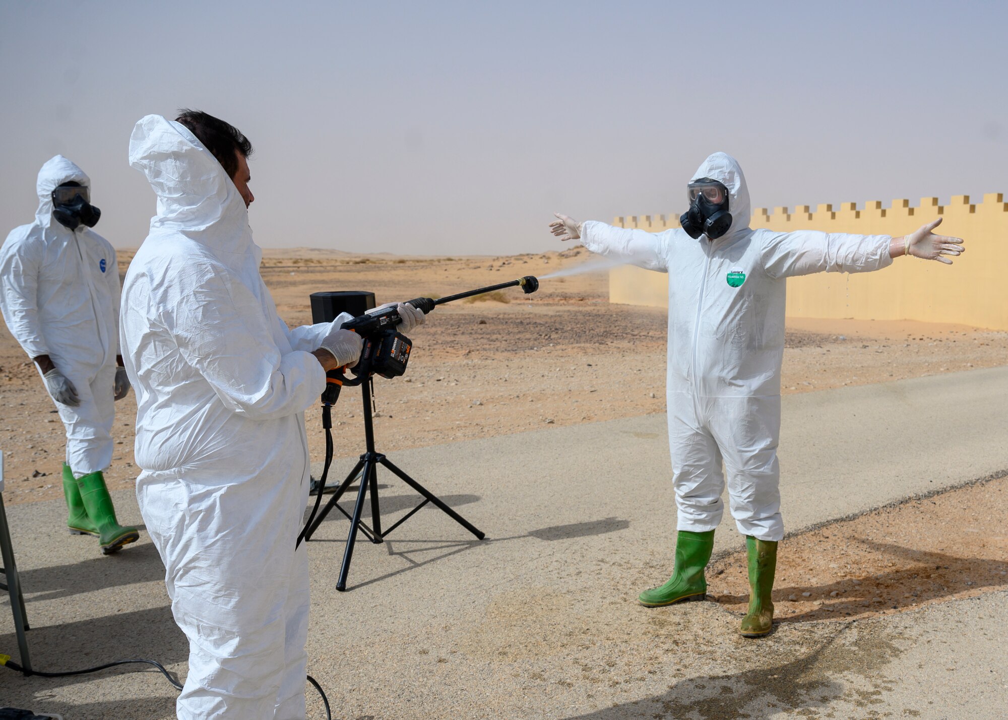 Members of the Royal Saudi Air Force spray members of the 378th Civil Engineer Squadron emergency management flight to practice decontaminating techniques after a chemical, biological, radiological and nuclear response exercise, Prince Sultan Air Base, Kingdom of Saudi Arabia, May 26, 2021. The combined exercise demonstrates the emergency management integration between USAF and RSAF CBRN response units while also familiarizing each unit with the other’s techniques and procedures. (U.S. Air Force photo by Senior Airman Samuel Earick)