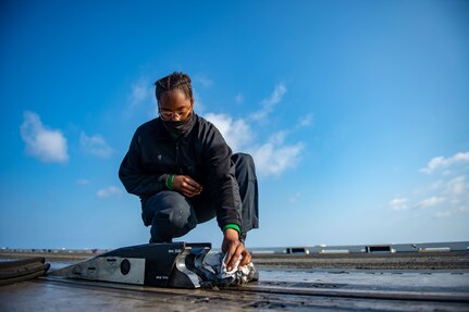 Aviation Boatswain's Mate (Equipment) Kyerra Williams, from San Bernardino, California, cleans the spreader of a catapult on the flight deck of the Nimitz-class aircraft carrier USS Harry S. Truman (CVN 75) during sea trials after completing an extended carrier incremental availability.