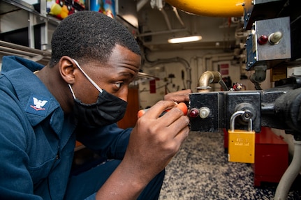 Electricians Mate 3rd Class Kishawn Harris, from Savannah, Georgia, rewires a directional control valve on the forward mess decks aboard the Nimitz-class aircraft carrier USS Harry S. Truman (CVN 75) during sea trials after completing an extended carrier incremental availability.