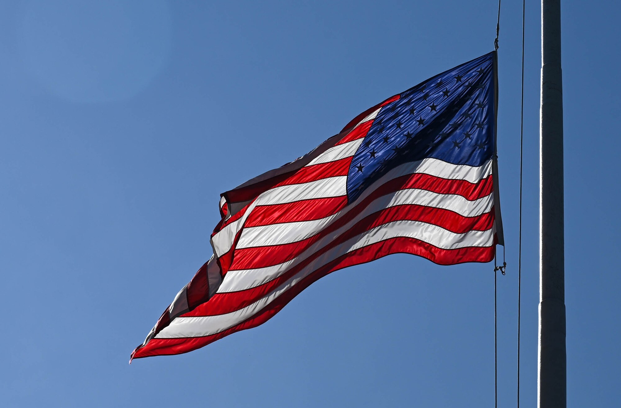 The United States Flag is lowered during the Memorial Day retreat ceremony at Joint Base Langley-Eustis, Virginia, May 27, 2021. The flag was then folded while the narrator explained the meaning of each fold. (U.S. Air Force photo by Senior Airman Sarah Dowe)