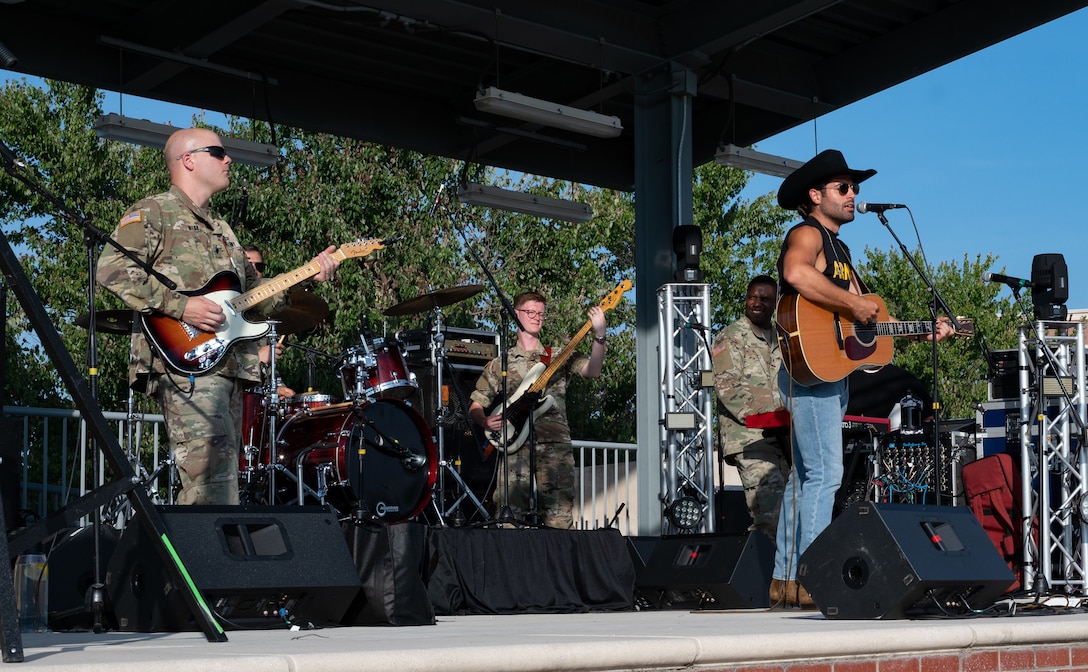 Austin Moody performs with the U.S. Army Training and Doctrine Command band “High Tide” during a concert at Joint Base Langley-Eustis, Virginia, May 27, 2021. Moody joined the band on stage during their opening to perform with the Soldiers. (U.S. Air Force photo by Staff Sgt. Chandler Baker)