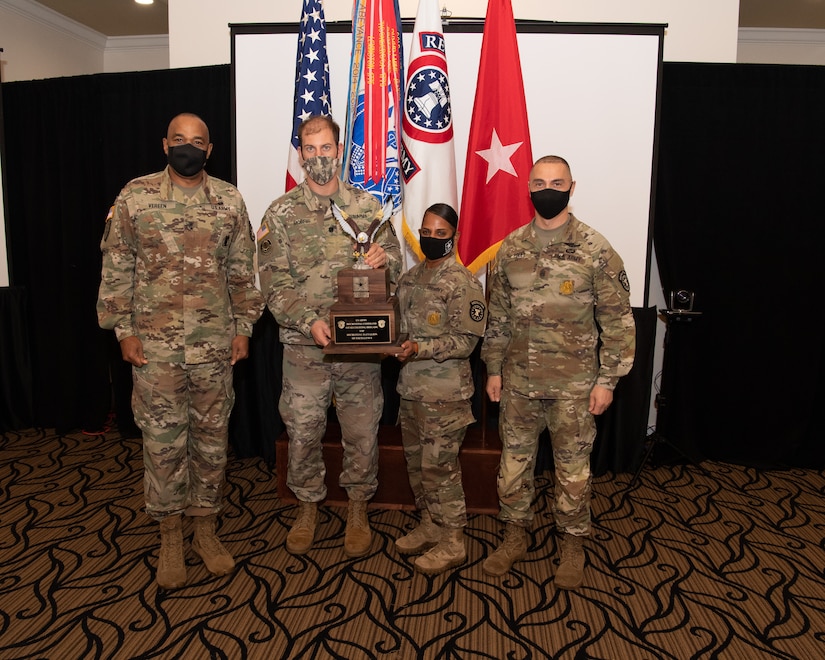 U.S. Army Soldiers posing with an award.