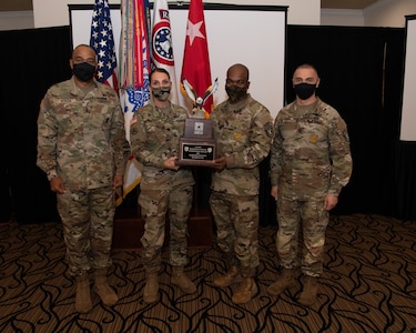 U.S. Army Soldiers posing with an award.