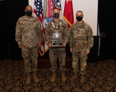 U.S. Army Soldiers posing with an award.