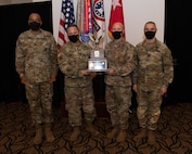 U.S. Army Soldiers posing with an award.