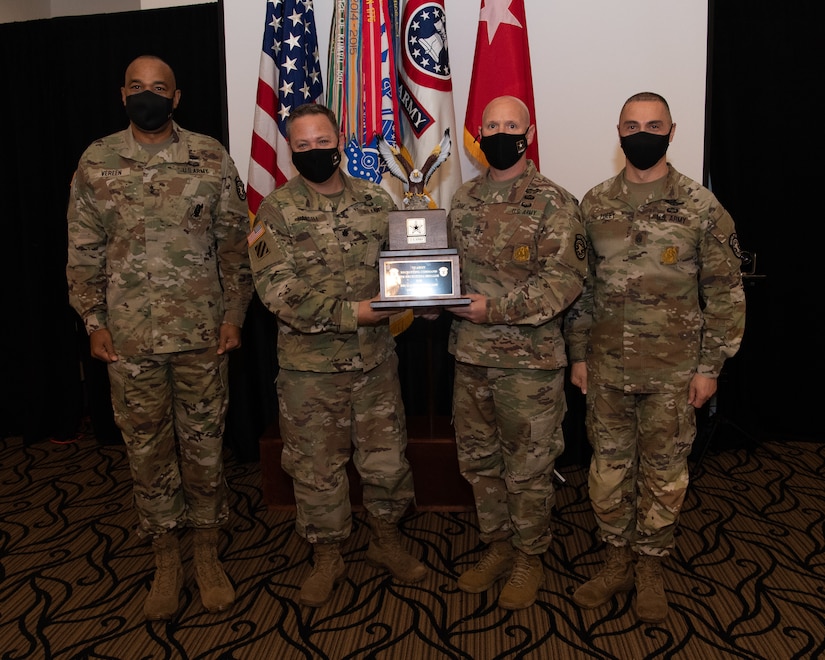 U.S. Army Soldiers posing with an award.