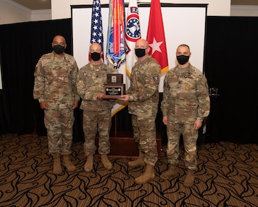 U.S. Army Soldiers posing with an award.