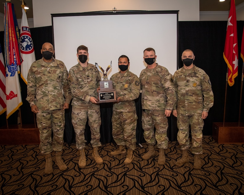 U.S. Army Soldiers posing with an award.