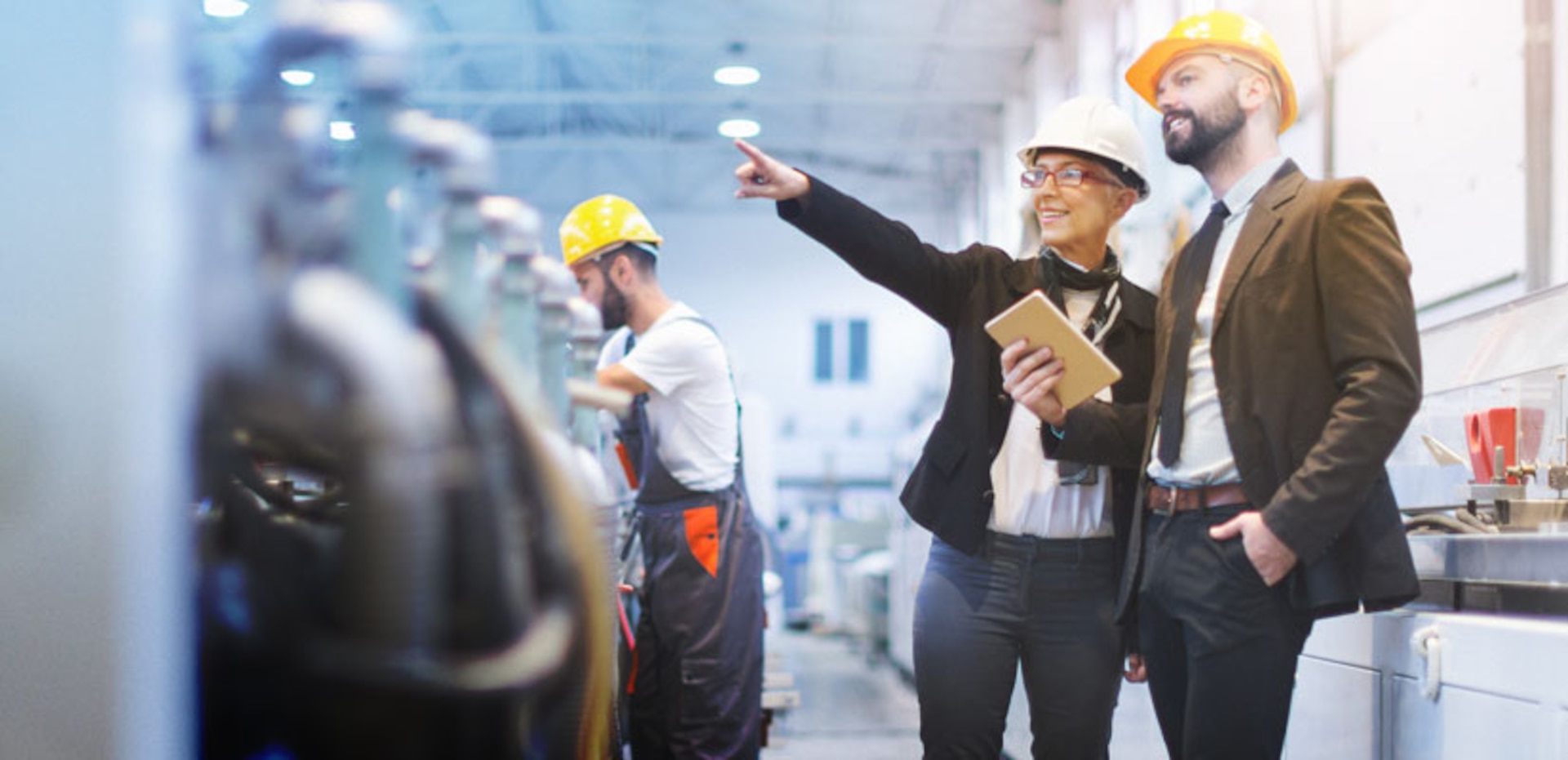 Two people wearing hard hats doing a floor check.