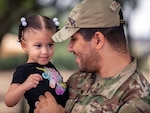 U.S. Air Force Senior Airman Brian Chambers, 502nd Contracting Squadron contract specialist, holds his daughter