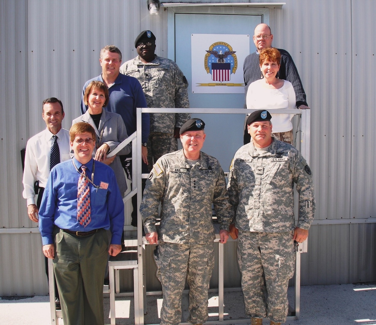 Group of seven men and two women pose during a May 2009 visit to MacDill Air Force Base in Tampa, Florida, from Former DLA Director Army Lt. Gen. Robert Dail.