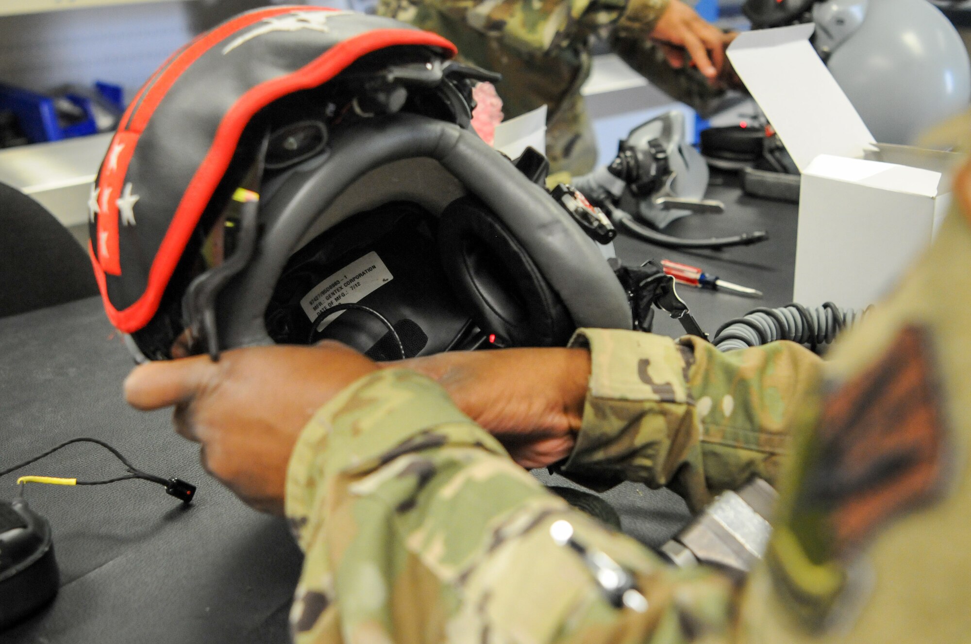 104th Operations Support Flight Airmen install SPYDR into a pilot's helmets Sept. 18, 2021, at Barnes Air National Guard Base, Massachusetts. The SPYDR system provides an audible warning when a pilot's oxygen saturation drops below a specific threshold, enhancing their safety and tactical capabilities. (U.S. Air National Guard photo by Senior Airman Camille Lienau)