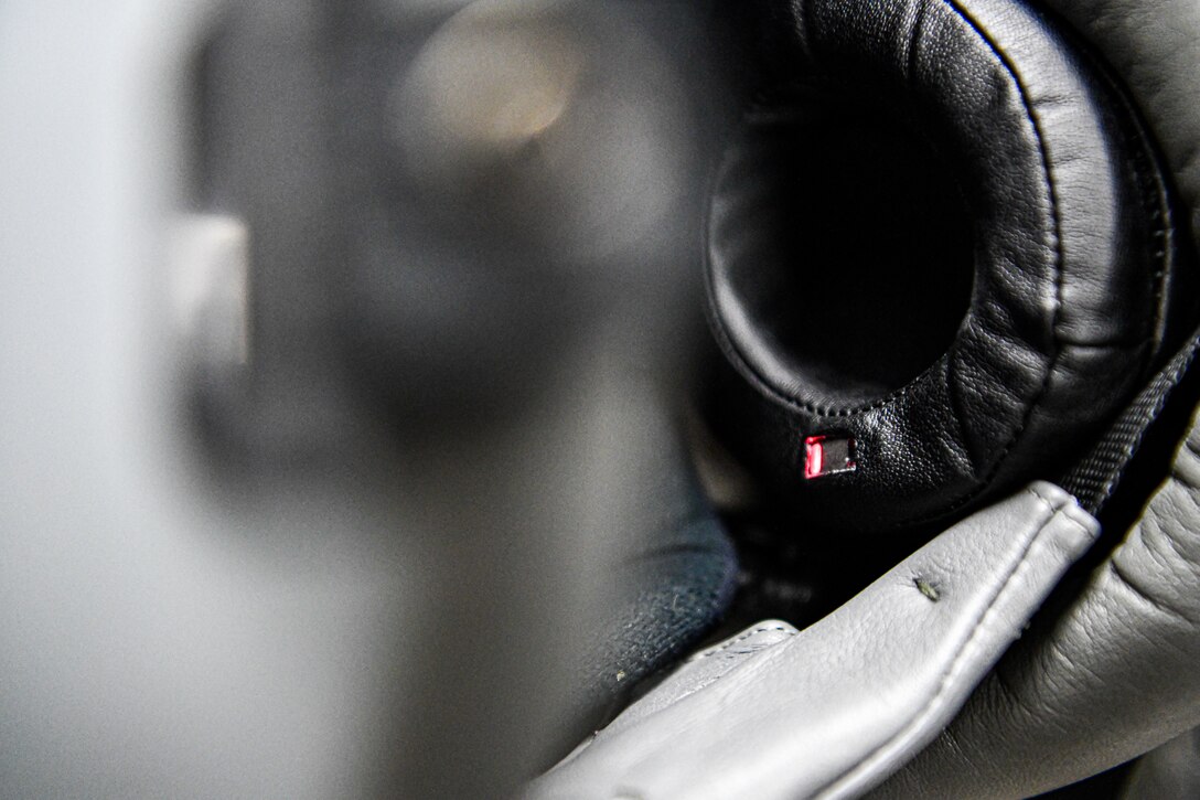 Lt. Col. Michael 'Shot' Glass shows the location of SPYDR in his helmet Oct. 28, 2021, at Barnes Air National Guard Base, Massachusetts. The SPYDR system provides an audible warning when a pilot's oxygen saturation drops below a specific threshold, enhancing their safety and tactical capabilities.(U.S. Air National Guard photo by Randy Burlingame)