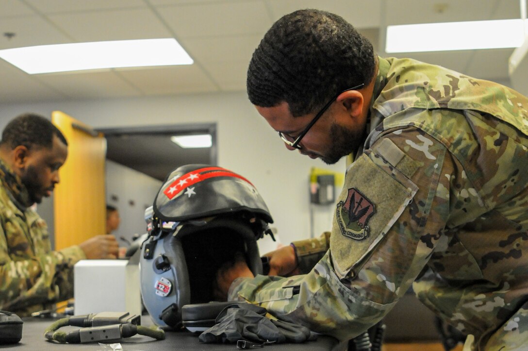 104th Operations Support Flight Airmen install SPYDR into a pilot's helmets Sept. 18, 2021, at Barnes Air National Guard Base, Massachusetts. The SPYDR system provides an audible warning when a pilot's oxygen saturation drops below a specific threshold, enhancing their safety and tactical capabilities. (U.S. Air National Guard photo by Senior Airman Camille Lienau)